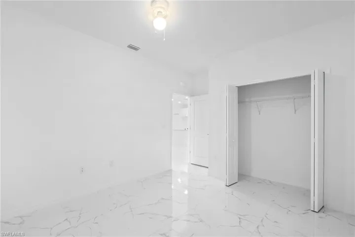 Unfurnished bedroom with a closet and light tile patterned floors