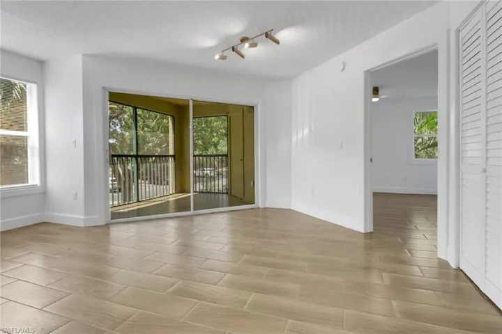 Empty room featuring a wealth of natural light, a textured ceiling, and baseboards