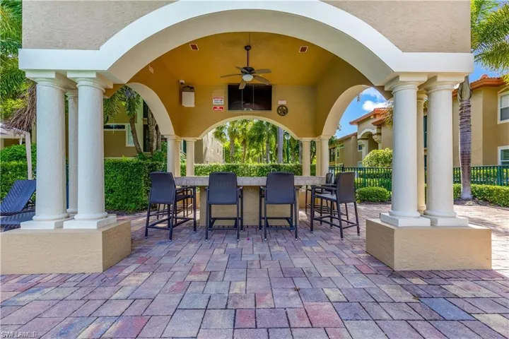View of patio featuring outdoor dry bar, ceiling fan, fence, and a gazebo