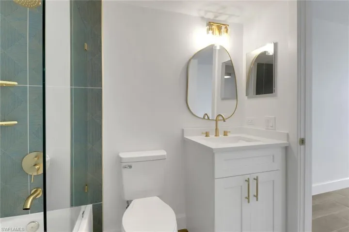 Full bath with a tub, vanity, a shower, toilet, and baseboards