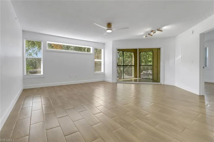 Unfurnished room with light wood finished floors, ceiling fan, baseboards, and rail lighting