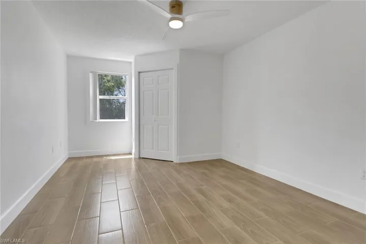 Unfurnished bedroom with light wood-style floors, ceiling fan, and baseboards