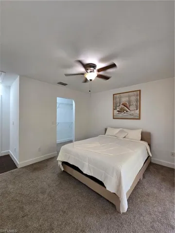 Bedroom featuring ceiling fan and dark carpet