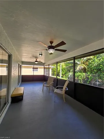 Unfurnished sunroom featuring ceiling fan