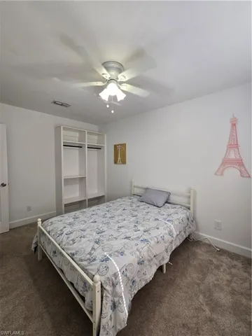 Carpeted bedroom featuring ceiling fan