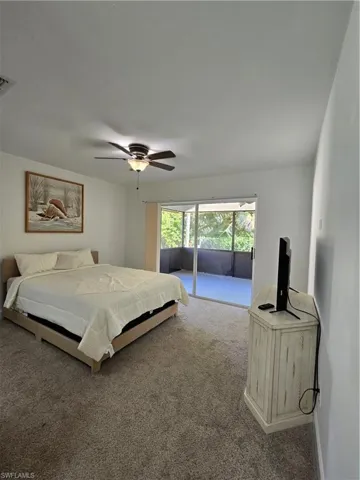 Carpeted bedroom featuring ceiling fan and access to exterior