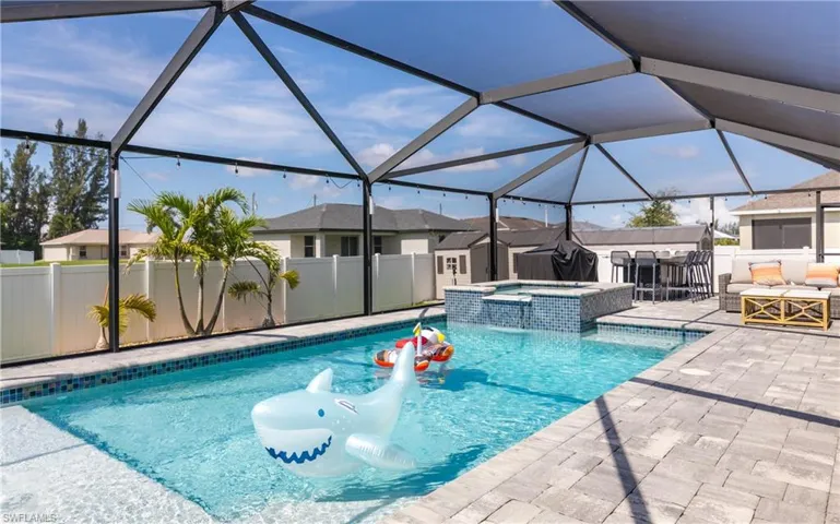 Screened-in swimming pool and spa with a paver deck
