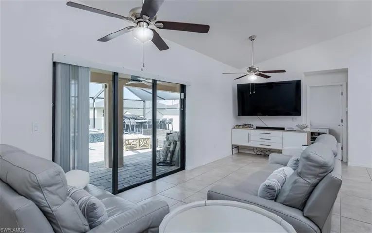 Living area featuring sliding glass doors opening to an outdoor screened enclosure