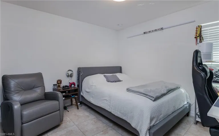 Room featuring light-toned walls, tile flooring, and a window with blinds