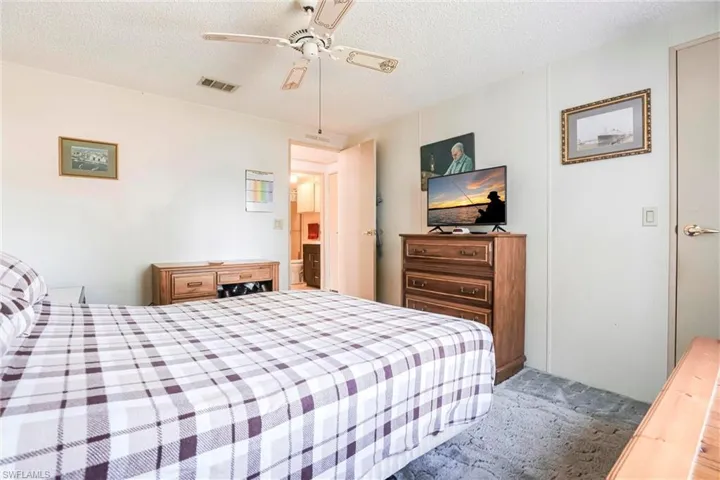 Bedroom featuring ceiling fan, carpet flooring, and a textured ceiling