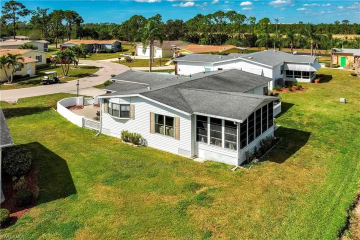 Rear view of house featuring a yard and a sunroom