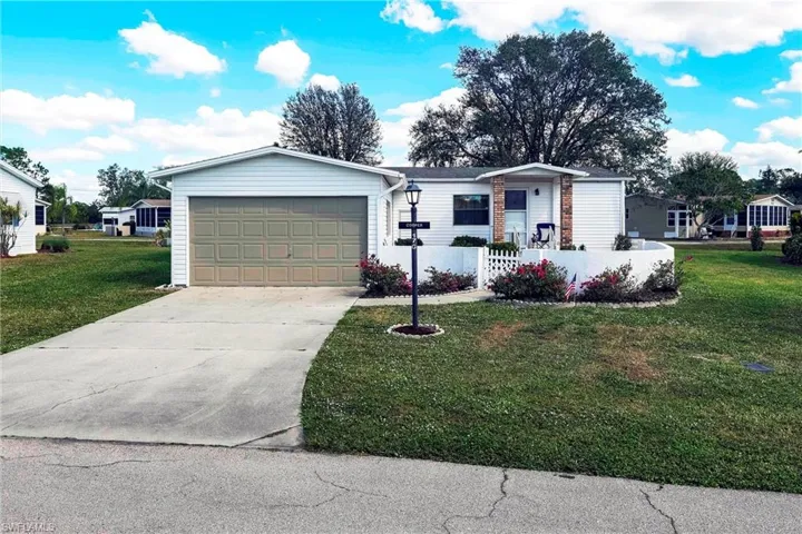Single story home featuring a garage and a front lawn