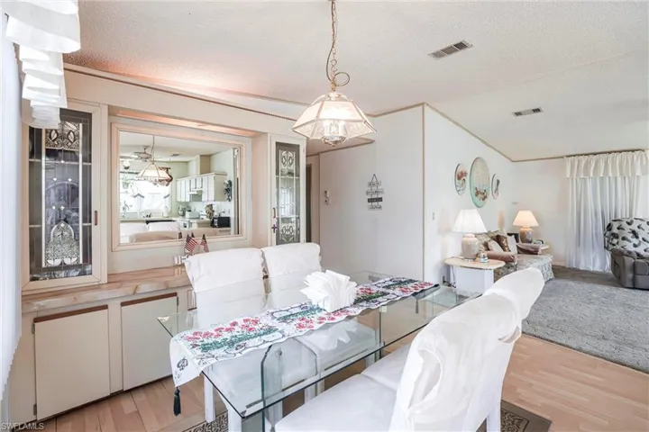Dining space with crown molding, light hardwood / wood-style flooring, and a textured ceiling