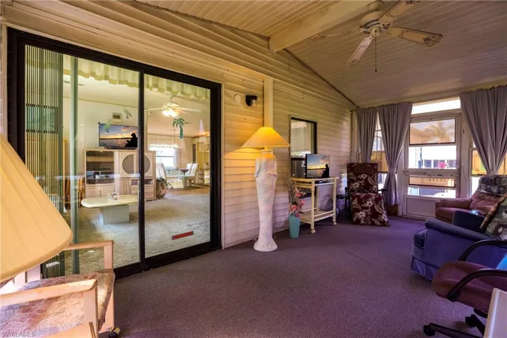 Sunroom / solarium with vaulted ceiling with beams, wooden ceiling, and ceiling fan