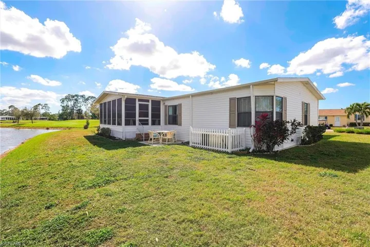 Back of property featuring a sunroom and a lawn