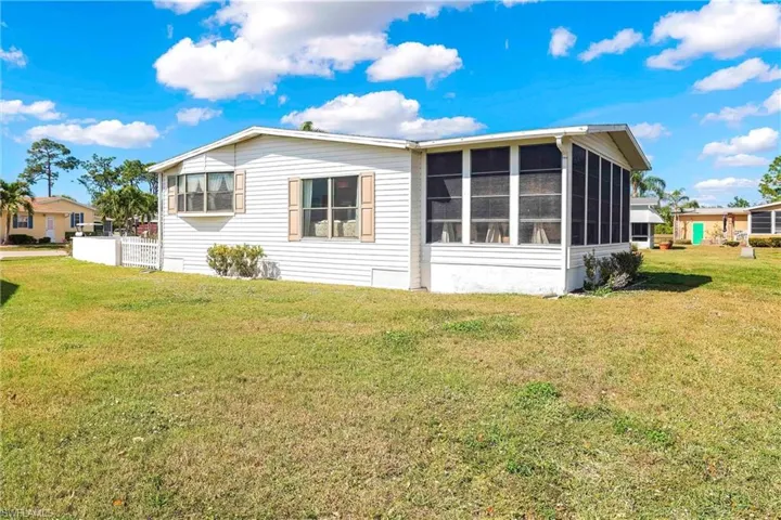 Back of house with a sunroom and a yard