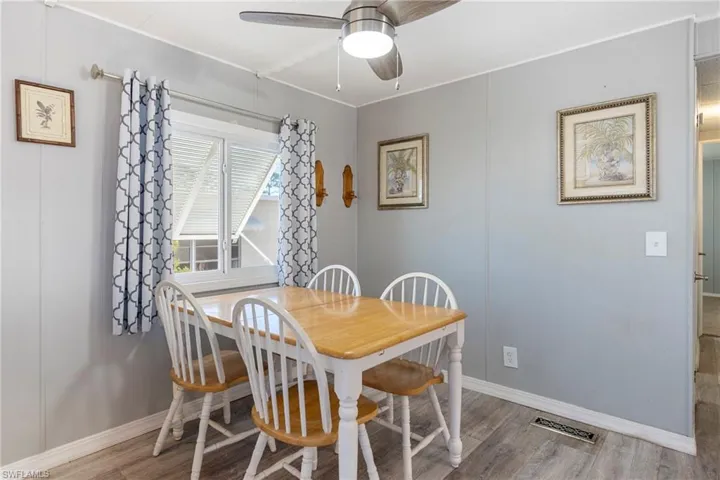 Dining room with ceiling fan, light wood finished floors, and a decorative wall
