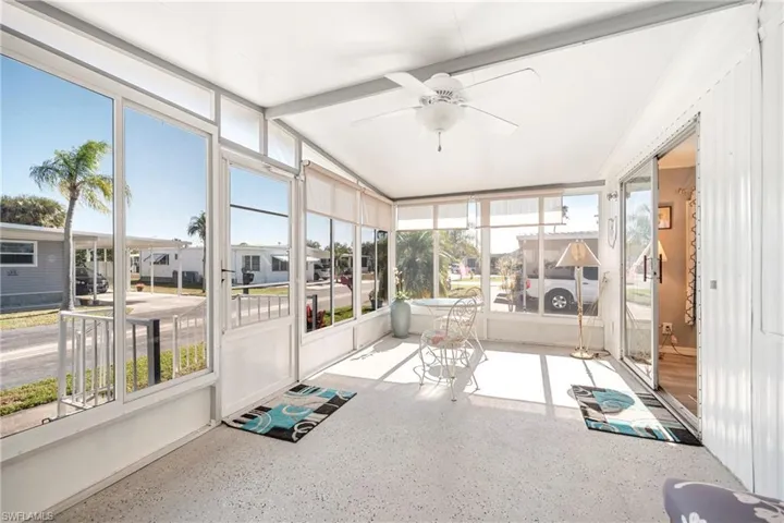 Sunroom / solarium featuring ceiling fan, healthy amount of natural light, and a residential view