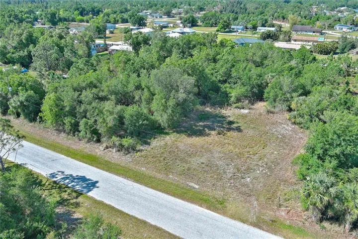 Aerial view of property and surrounding area with a heavily wooded area