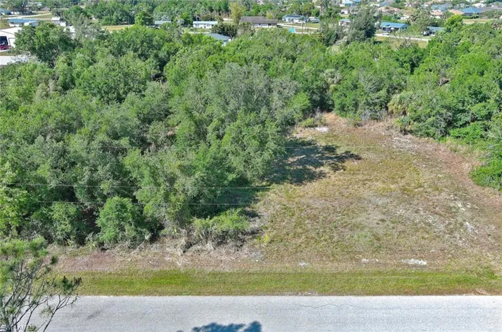 View of property location with a heavily wooded area
