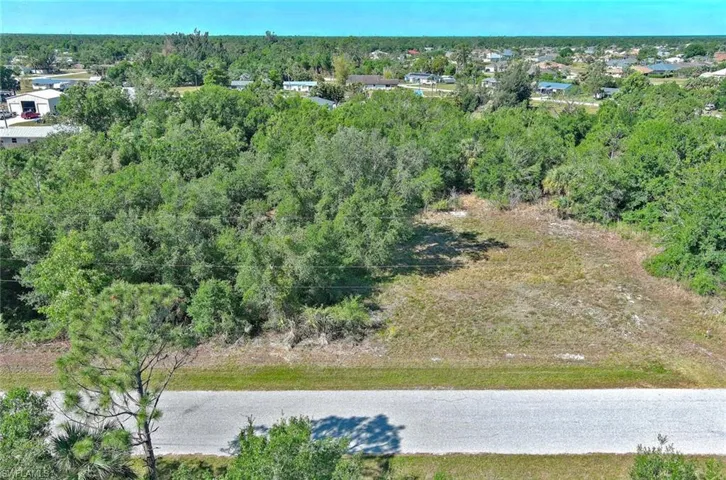 Aerial overview of property's location with a heavily wooded area