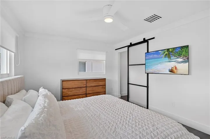 Bedroom featuring a barn door and a ceiling fan