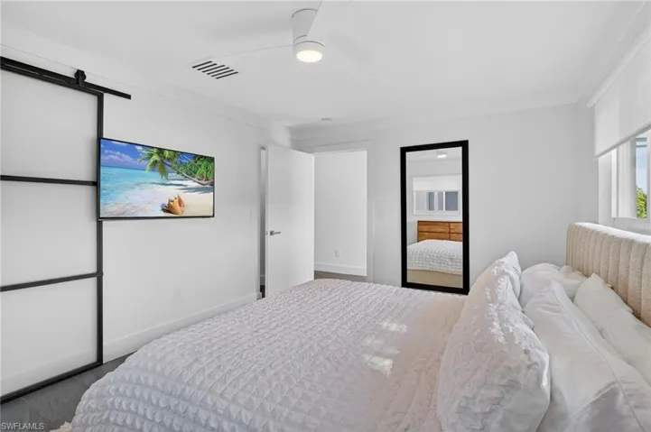 Bedroom with a barn door and ceiling fan