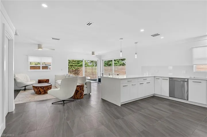 Kitchen featuring white cabinetry, decorative light fixtures, a peninsula, dishwasher, and recessed lighting