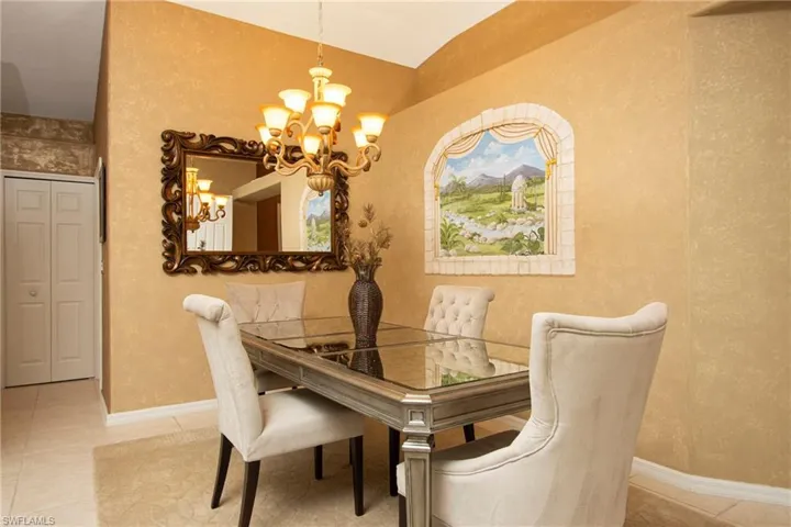 Dining room with light tile patterned floors and a notable chandelier