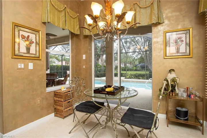 Dining area with light tile patterned floors and a chandelier