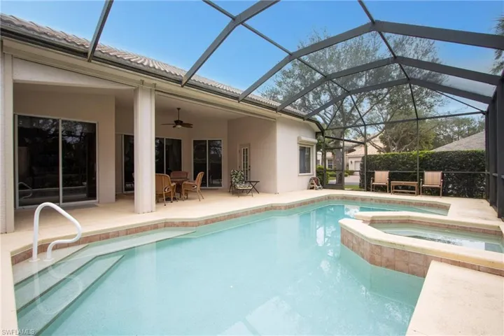 View of pool with a patio, an in ground hot tub, glass enclosure, and ceiling fan