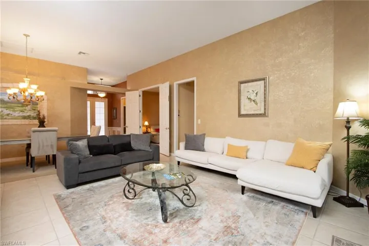 Living room with a notable chandelier and light tile patterned flooring