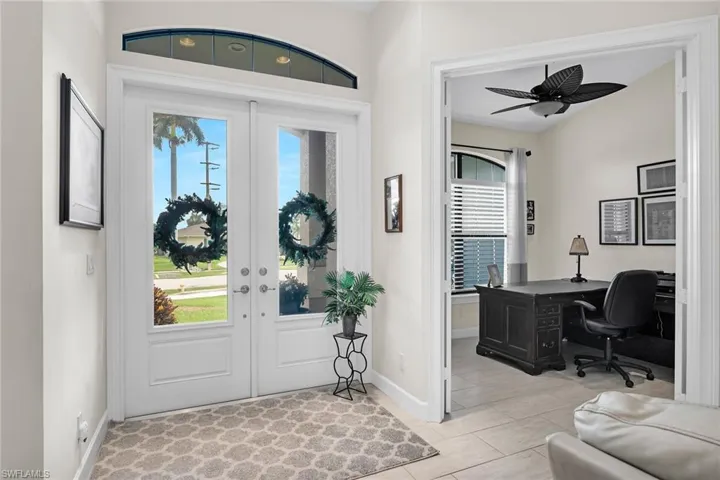 Entrance foyer with french doors, baseboards, and ceiling fan