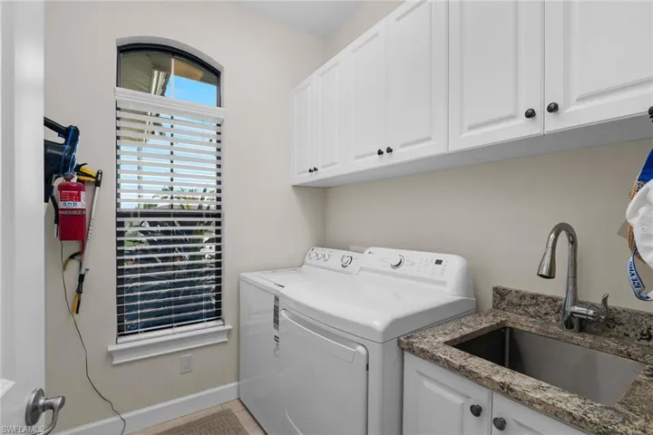 Laundry room with washer and clothes dryer, cabinet space, and baseboards