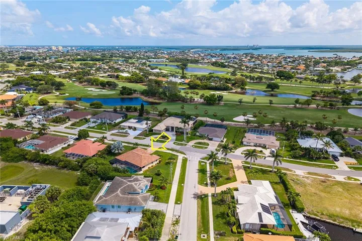 Aerial perspective of suburban area featuring a large body of water and a local golf course
