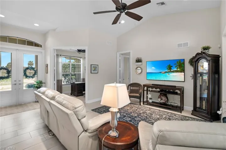Living area featuring french doors, ceiling fan, recessed lighting, high vaulted ceiling, and baseboards