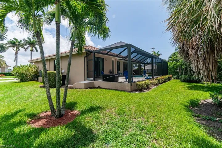 Back of property featuring stucco siding, a lawn, a patio area, and a tile roof
