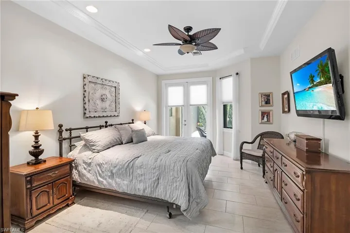 Bedroom featuring access to exterior, a raised ceiling, recessed lighting, and ceiling fan