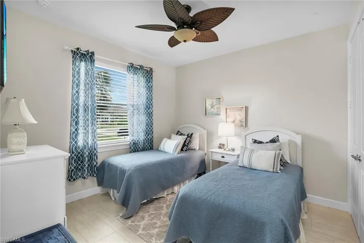 Bedroom featuring baseboards, a ceiling fan, and light wood finished floors