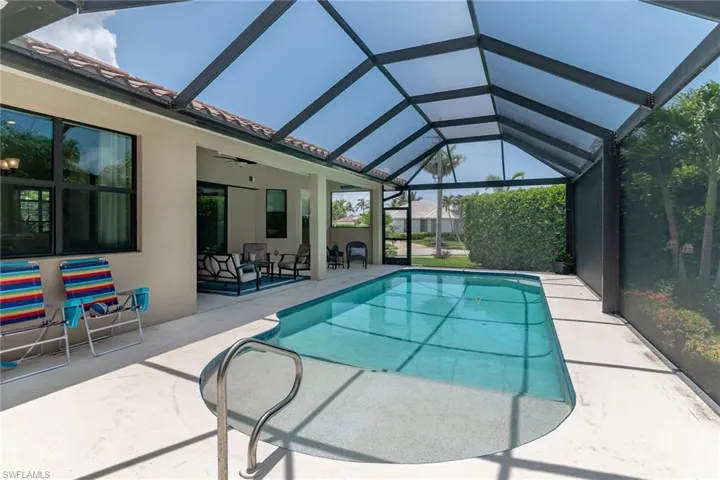 Swimming pool featuring a patio area, ceiling fan, and glass enclosure