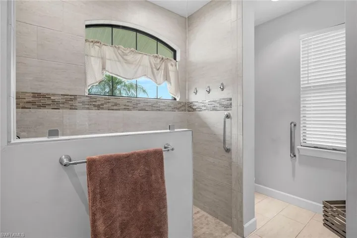 Bathroom with a walk in shower and tile patterned floors