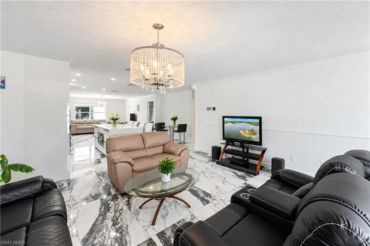 Polished stone-finish tile flooring, crystal drum chandelier, and recessed lighting