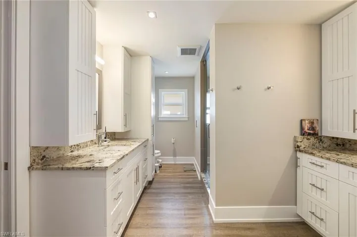 Full bath featuring vanity, dark wood-type flooring, and recessed lighting