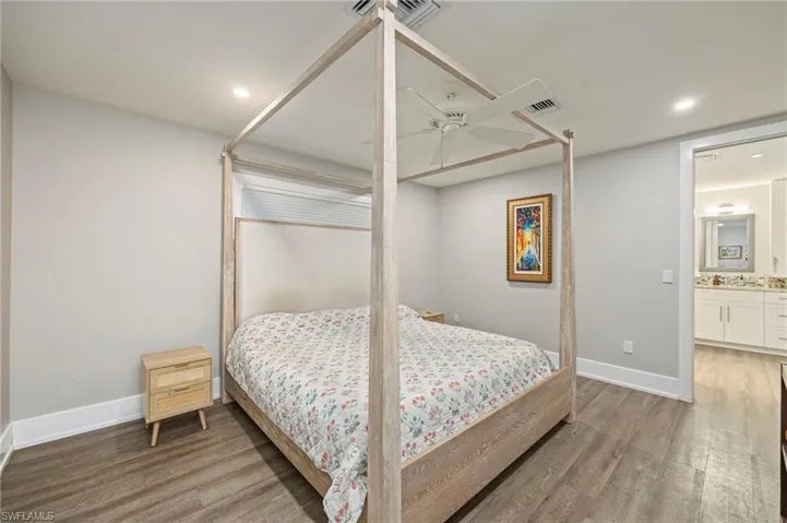 Bedroom with light wood-style flooring, a ceiling fan, recessed lighting, and connected bathroom