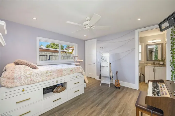 Bedroom featuring dark wood-type flooring, a ceiling fan, ensuite bathroom, and recessed lighting