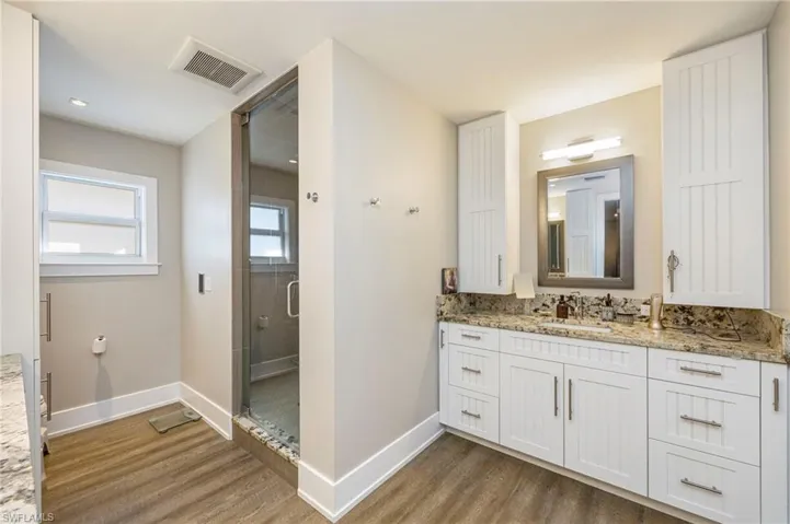 Bathroom featuring vanity, a stall shower, and dark wood-style flooring