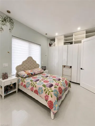 Bedroom featuring light-toned flooring and a light-colored wall