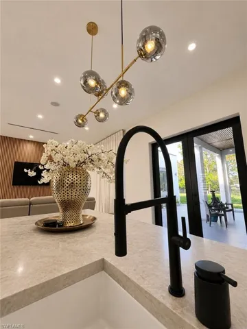 Island workstation featuring an undermount sink, a matte black gooseneck faucet, and a light-toned stone countertop