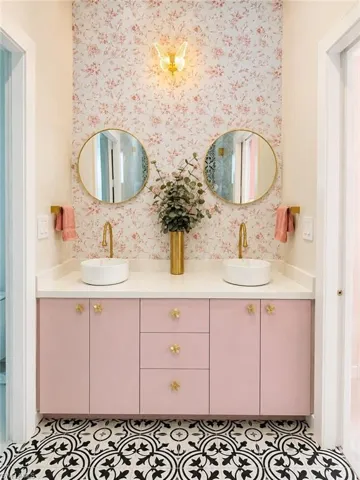 Dual basin vanity with a white countertop and pink cabinetry