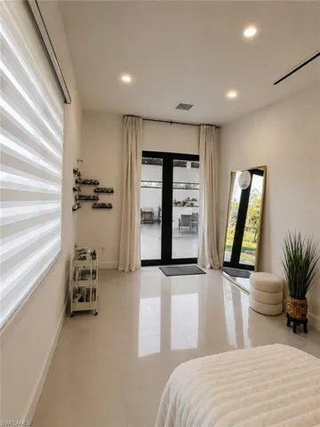 Room featuring large format tile flooring, recessed ceiling lighting, and a wide window with modern blinds